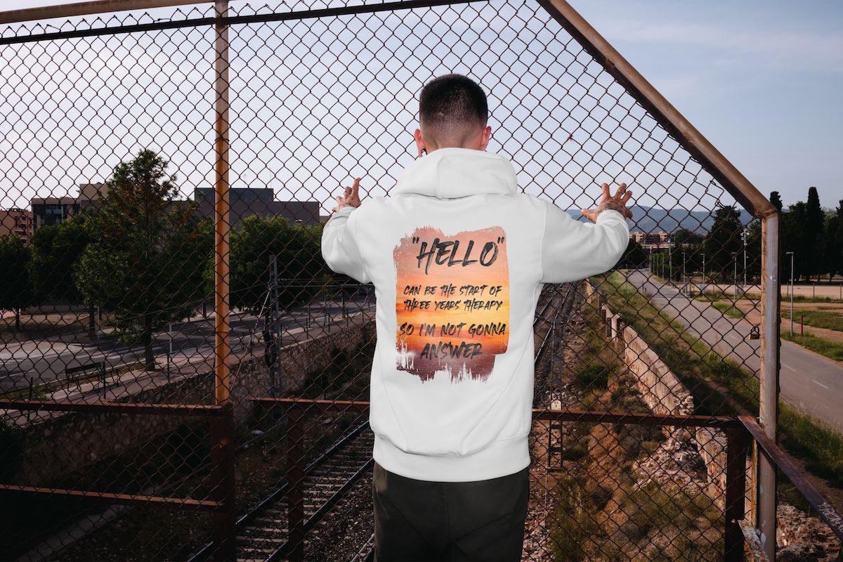 Hello Organic Cotton Hoodie with sunset backdrop design against a natural outdoor setting